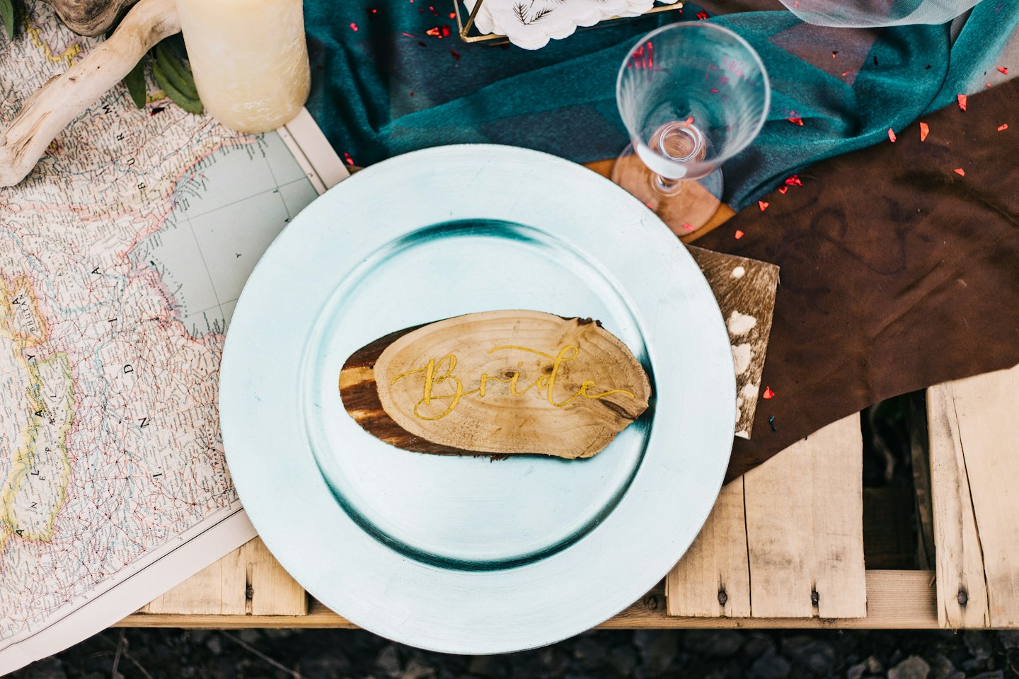 Rustic table setting with wooden slice place card reading 'Bride'.
