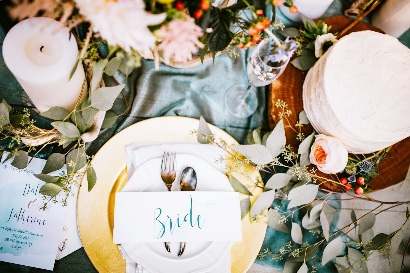 Elegant wedding table setting with cake and floral decorations.